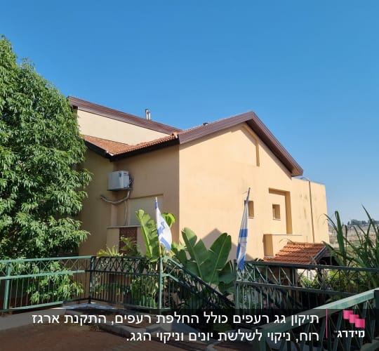 גג רעפים חום על מבנה צהוב עם דגלים